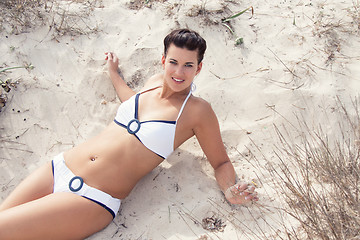 Image showing happy young woman sitting in sand dunes beach 