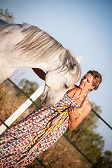 Image showing young woman walking a road with horse