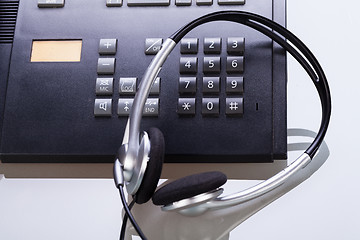 Image showing office desk with telephone and headset objects 