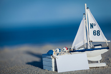 Image showing sailing boat and seashell in sand decoration closeup