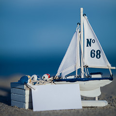 Image showing sailing boat and seashell in sand decoration closeup
