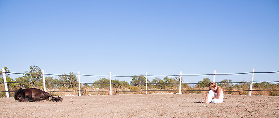 Image showing young woman training horse outside in summer