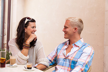 Image showing happy young couple sitting outside cafe restaurant drinking coffee 