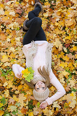 Image showing attractive young woman relaxing in atumn park outdoor