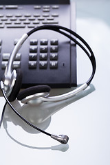 Image showing office desk with telephone and headset objects 