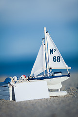 Image showing sailing boat and seashell in sand decoration closeup