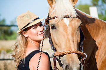 Image showing young woman training horse outside in summer