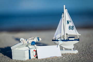 Image showing sailing boat and seashell in sand decoration closeup