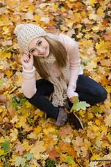 Image showing attractive young woman relaxing in atumn park outdoor