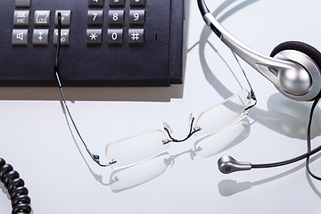 Image showing working place office desk table headset glasses telephone