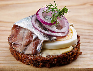 Image showing brown bread canape with anchovies decorated with red onion and d