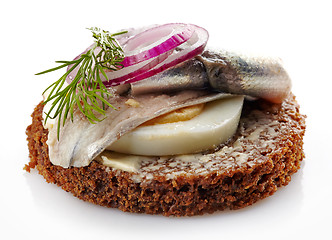 Image showing brown bread canape with anchovies decorated with red onion and d