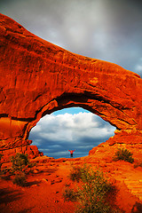 Image showing Woman staying with raised hands inside an Arch