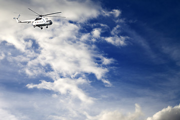 Image showing Helicopter in blue sky with clouds