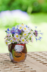 Image showing Bouquet of daisies on the table in the garden. Summer background