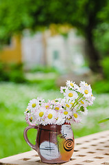 Image showing Bouquet of daisies on the table in the garden. Summer background