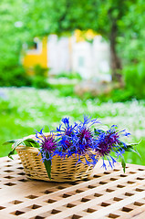 Image showing Bunch of cornflowers in a wicker basket. Summer background