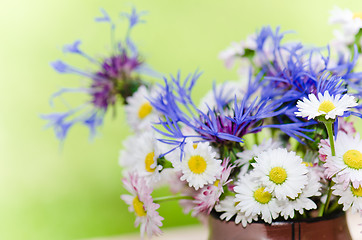 Image showing Bouquet of daisies on the table in the garden. Summer background