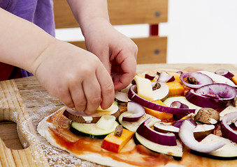 Image showing small hands preparing pizza