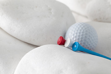 Image showing Golf ball and tees between white stones