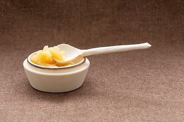 Image showing Pot of honey and wooden spoon on a burlap