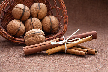 Image showing Walnuts in a wicker basket and cinnamon