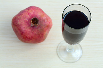 Image showing Goblet of wine and a pomegranate on the table