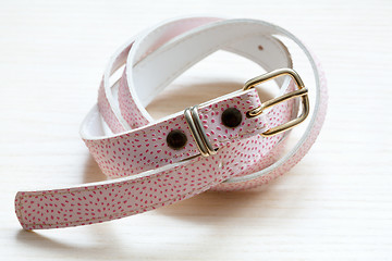 Image showing pink women style belt on a light wooden background