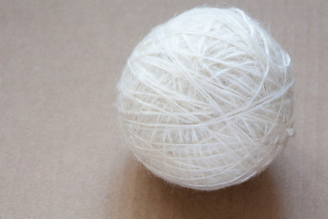 Image showing Ball of white wool yarn on cardboard background