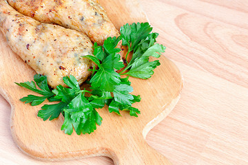 Image showing Fried chicken legs with parsley on the board