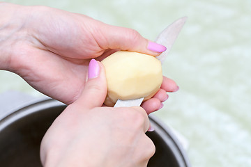 Image showing Hands with knife cut the potatoes into the pan