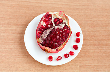 Image showing The cut pomegranate and grains on a plate