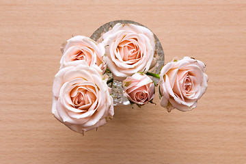Image showing pink roses in a vase on a wooden desk