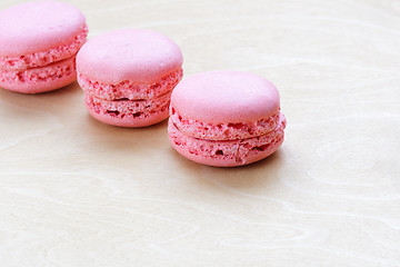 Image showing pink macaron on wooden background