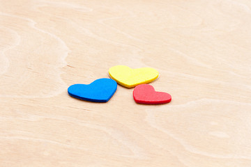 Image showing multicolored hearts on a white wooden background