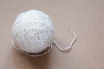 Image showing Ball of white wool yarn on cardboard background