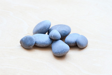 Image showing Smooth river rocks on a white wooden background