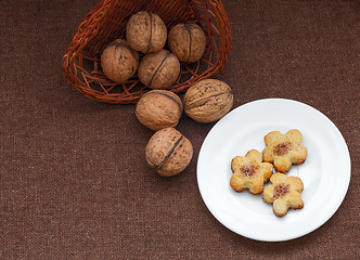 Image showing wicker basket with nuts and pastry on a plate