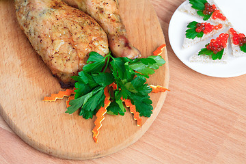 Image showing Fried chicken legs with parsley and red caviar