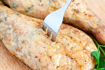 Image showing Pierce the chicken with a fork on a cutting board