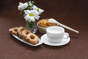 Image showing honey, cookies, cup and a vase of daisies