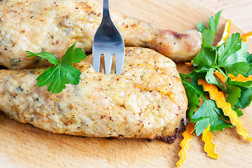 Image showing Pierce the chicken with a fork on a cutting board