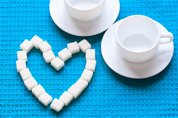 Image showing White Sugar in heart shape on blue napkin