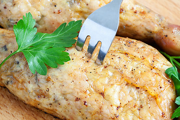 Image showing Pierce the chicken with a fork on a cutting board