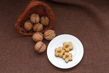 Image showing wicker basket with nuts and pastry on a plate