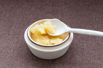 Image showing Pot of honey and wooden spoon on a cloth