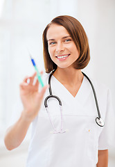 Image showing female doctor holding syringe with injection