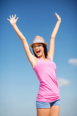 Image showing girl with hands up on the beach