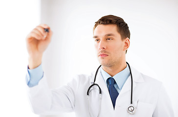 Image showing young doctor working with something imaginary