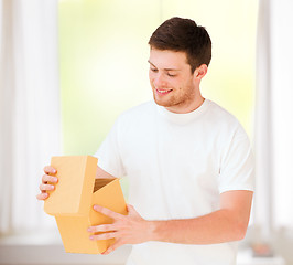 Image showing man in white t-shirt with gift box